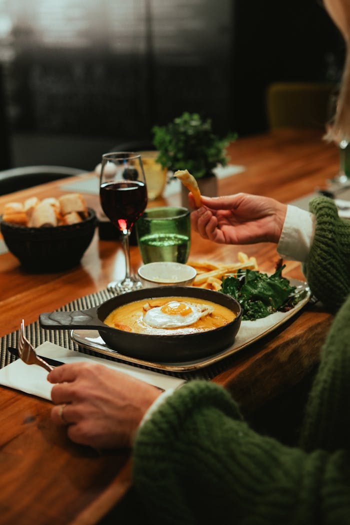 Menu A delightful meal featuring cheese, wine, fries, and salad in a cozy French setting.