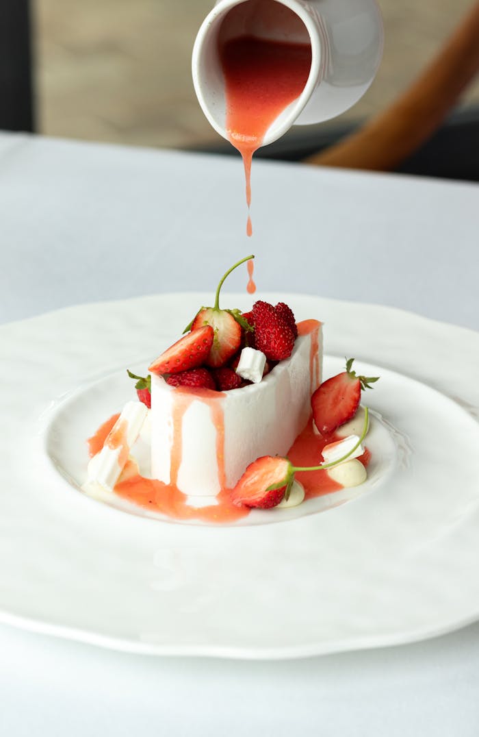 Home Indulge in a gourmet dessert with fresh strawberries and silky sauce in a French restaurant.