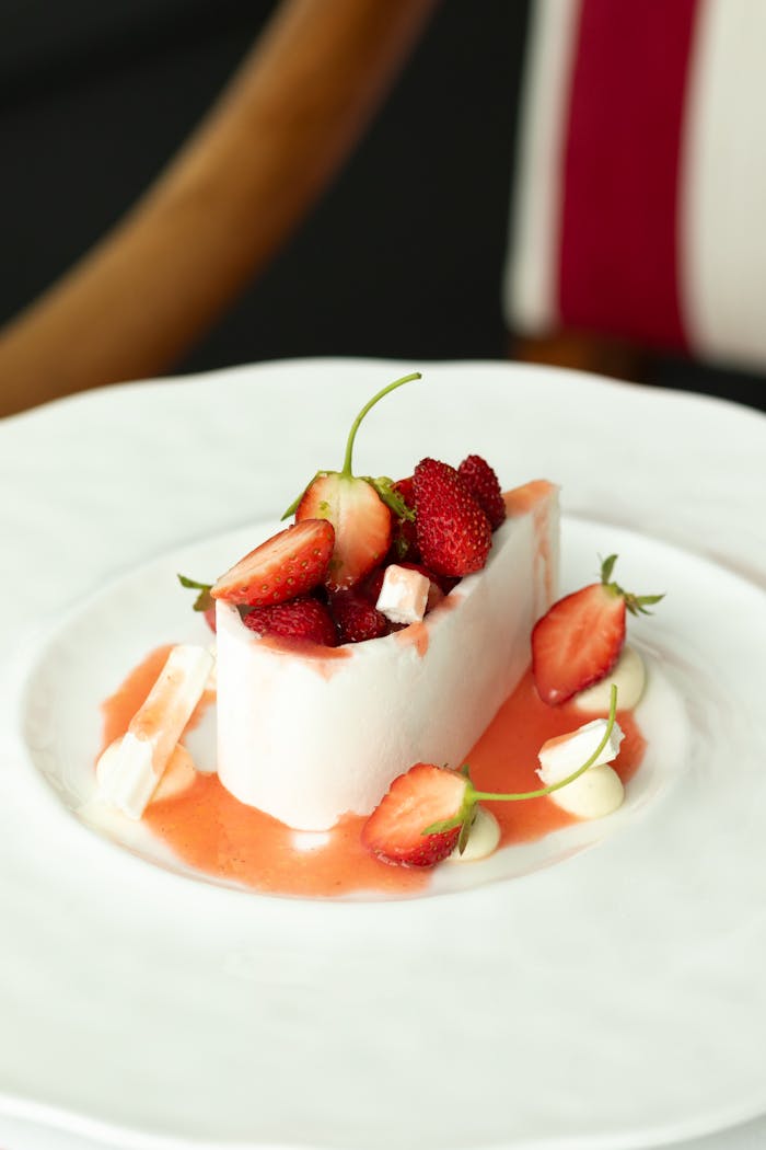 Menu Elegant French dessert garnished with fresh strawberries, captured in a stylish restaurant setting.