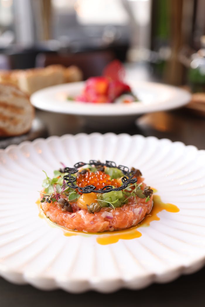 Home Delicious salmon tartare topped with caviar on a decorative plate, ideal for fine dining visuals.